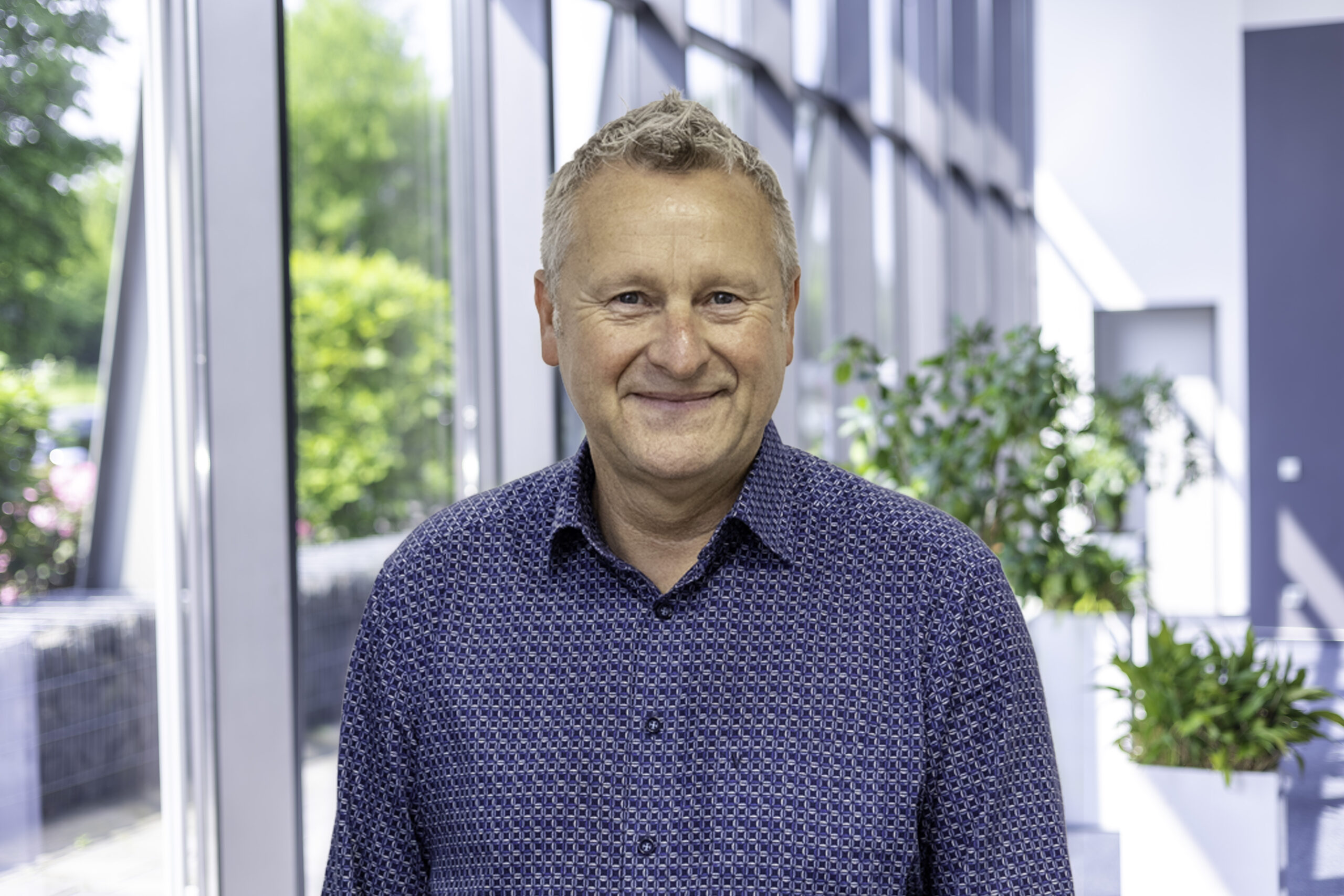 Joachim Kohn, specjalista ds. sieciowych rozwiązań energetycznych, w foyer przy oknach.