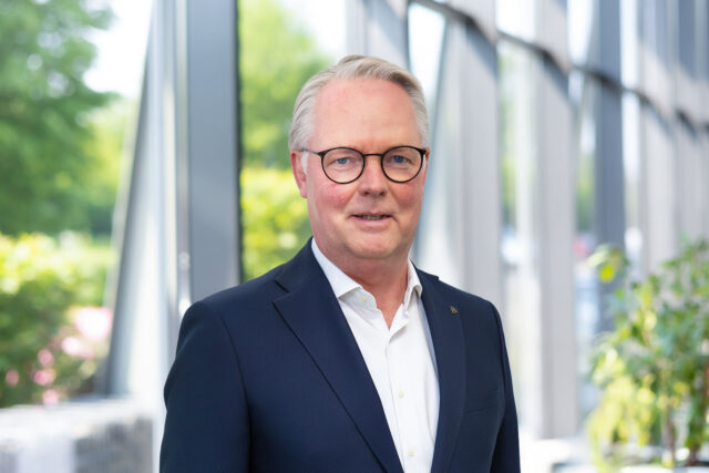 CFO Jürgen Deters w holu wejściowym na tle przeszklonej ściany.