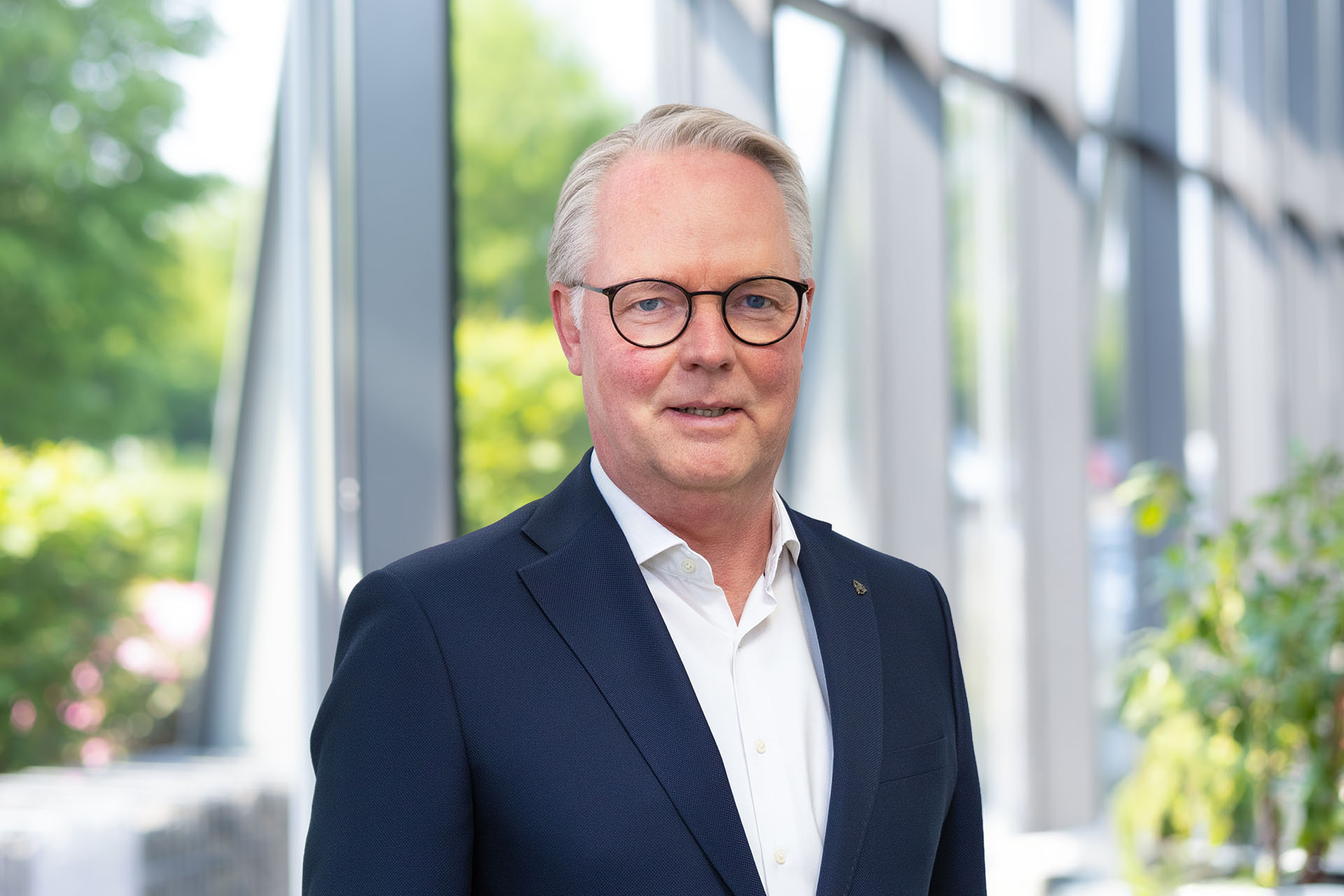 CFO Jürgen Deters w holu wejściowym na tle przeszklonej ściany.