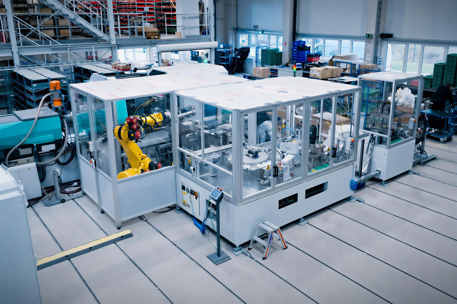 Zautomatyzowana maszyna specjalna z celą robota w hali produkcyjnej.